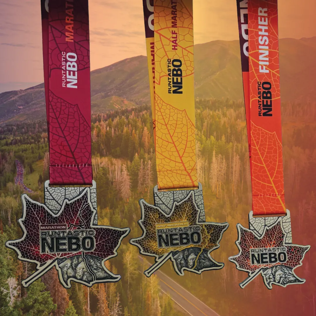 Three Runtastic NEBO 2026 Finisher Medals in front of Mt NEBO in Payson, Utah